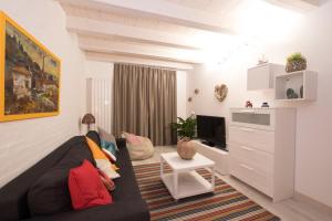 Una sala de estar con un sofá y un televisor. en Happy House, en Viareggio
