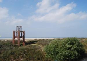 einen Turm auf einem Hügel inmitten eines Feldes in der Unterkunft Hotel das Miramar in Borkum