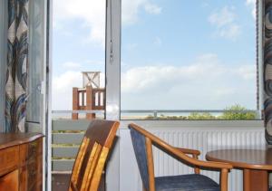 a room with a table and chairs and a view of the ocean at Hotel das Miramar in Borkum