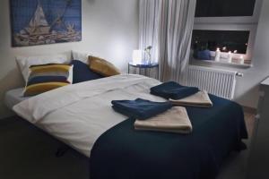 a bedroom with a bed with two towels on it at Sea Haven - Morska Przystań in Jelitkowo