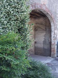 een ingang naar een bakstenen gebouw met een ijzeren poort bij Agriturismo Cascina Rossano in Provaglio d'Iseo