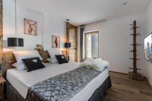 a bedroom with a large bed with white sheets at Chalet Chez Sylvain in Le Fornet