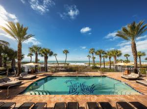 a swimming pool with palm trees and a beach at The Residences on Siesta Key Beach by Hyatt Vacation Club in Sarasota