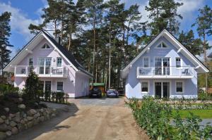 ein Haus mit zwei weißen Häusern in der Unterkunft Ferienhaus Müritzidyll / OG-Appartement in Marienfelde