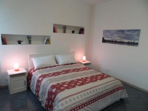 a bedroom with a bed with two candles on two tables at la casa di rita in Mestre