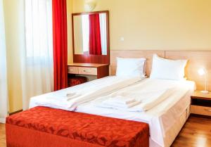 1 dormitorio con 1 cama blanca grande con reposapiés rojo en Guest House Panorama 3D, en Varshets