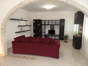 la casa di rita في ميستر: غرفة معيشة مع أريكة حمراء و ممر