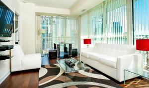 a living room with a white couch and a large window at Pathway Suites in Mississauga