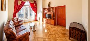 sala de estar con sofá y TV en Grand Lviv Apartment I (1 of 3) en Leópolis