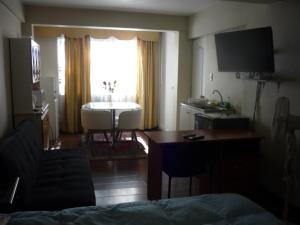 sala de estar con escritorio y cocina con ventana en Rodeo Departamentos Amoblados, en Rancagua