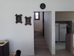 a room with a white wall and a hallway with a refrigerator at Casa Rústica em Gravatá in Gravatá