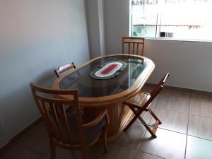 una mesa de comedor con sillas y un pastel. en Residencial Corrêa, en Penha