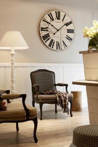 a room with a chair and a clock on the wall at Hotel America in Cannes