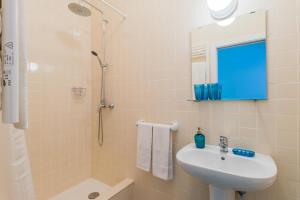 a bathroom with a sink and a shower with a mirror at Casa Bonecos Rebeldes in Lisbon +13 photos