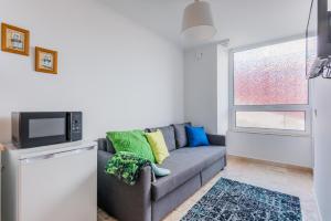 a living room with a couch and a tv at Casa Bonecos Rebeldes in Lisbon