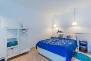 a bedroom with a blue bed and a dresser at Casa Bonecos Rebeldes in Lisbon