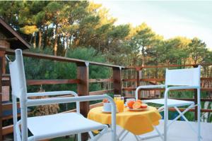 eine Terrasse mit 2 Stühlen und einem Tisch mit Orangen darauf in der Unterkunft Complejo Aroma's in Mar de las Pampas