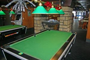 a pool table in a bar with green at Hôtel Notre Dame Des Neiges in La Féclaz