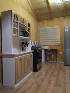a large kitchen with a refrigerator and a table at Cabañas Campos de Frutillar in Frutillar +8 photos
