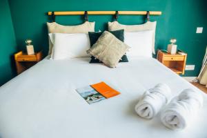 Una cama blanca grande con toallas. en Selina Porto en Oporto