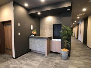 an office lobby with a counter and a potted plant at Hotel Route-Inn Koga Ekimae in Koga