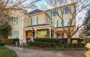 Una casa amarilla con adornos navideños. en Montgomery Inn BnB en Versailles