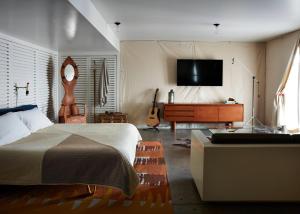a bedroom with a bed and a flat screen tv at Ace Hotel and Swim Club Palm Springs in Palm Springs
