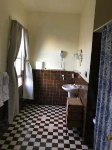 uma casa de banho com piso em xadrez preto e branco em Union Hotel em Benicia