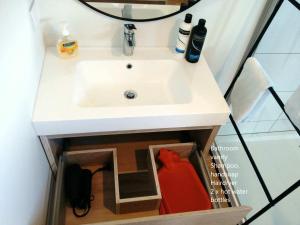 a white sink in a small bathroom with a shower at Ridge View in Wanaka +7 photos