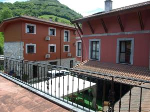 uma varanda com vista para dois edifícios e um carro em Hotel - Apartamentos Peña Santa em Onís