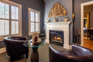 a living room with two chairs and a fireplace at Gruene River Hotel & Retreat in New Braunfels