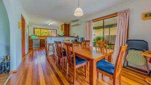 a kitchen and dining room with a wooden table and chairs at Driftwood On Anderson Free Wifi in Inverloch