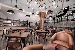 un restaurant avec des tables et des chaises ainsi qu'un bar dans l'établissement favehotel S. Parman Medan, à Medan