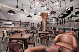 a restaurant with tables and chairs and a bar at favehotel S. Parman Medan in Medan