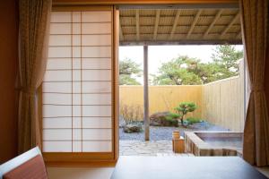 a room with a sliding door to a garden at Hotel Keipu in Hakodate