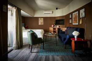 a bedroom with a bed and a couch and a table at Josh Hotel in Bangkok