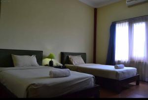 a bedroom with two beds and a window at Hotel Tiger in Yogyakarta +22 photos
