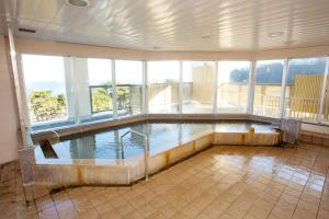 a large indoor swimming pool in a building with windows at Hotel Keipu in Hakodate