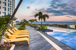 una fila di sedie a sdraio gialle sul tetto di un edificio di C Suites at Mactan Newtown a Mactan