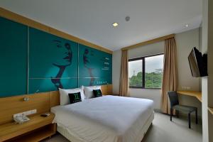 um quarto de hotel com uma cama grande e uma janela em Zodiak MT Haryono by KAGUM Hotels em Jacarta