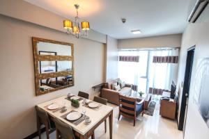 a dining room and living room with a table and a mirror at C Suites at Mactan Newtown in Mactan