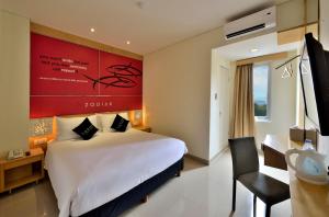 een hotelkamer met een groot bed en een bureau bij Zodiak Kebon Jati by KAGUM Hotels in Bandung