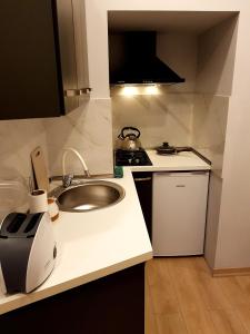a small kitchen with a sink and a stove at Kita's apartment in Tbilisi City