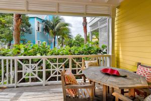 a porch with a wooden table and chairs on a deck at VALENTINES RESORT & MARINA in Harbour Island