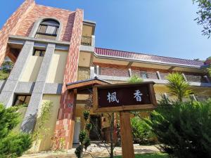 a building with a sign in front of it at 苗栗南庄 春友彩虹民宿SpringYU in Nanzhuang
