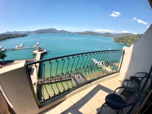 uma varanda com cadeiras e vista para um rio em Ming Yue Hu Hotel em Yuchi