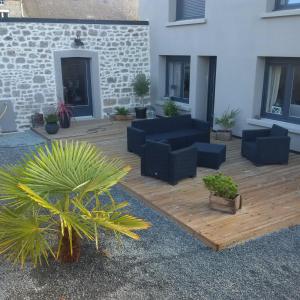 une terrasse avec des canapés et des plantes devant un bâtiment dans l'établissement le gite de sandrine, à Réville