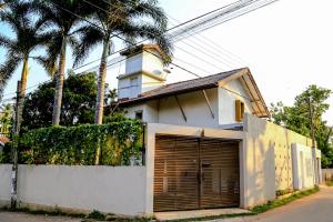 uma casa branca com garagem e palmeiras em Eden Studio Apartments - 1 em Colombo