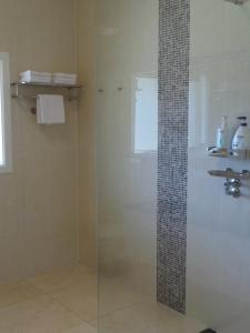 a bathroom with a shower, sink, and mirror at Colin's Garden in Bomaderry