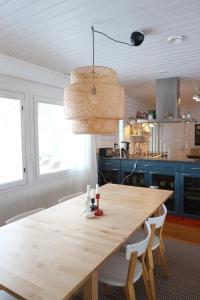 una cucina con tavolo e sedie in legno di Ilmola resort by the river a Keminmaa